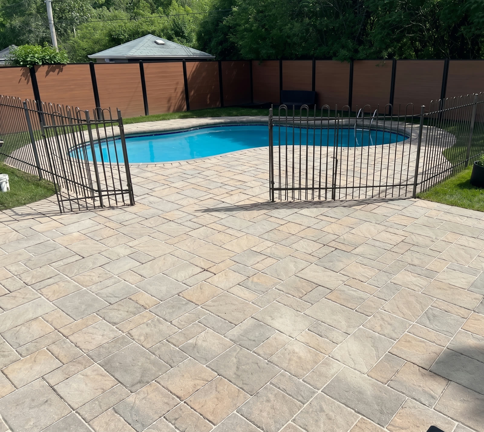 A paver pool deck with fresh polymeric sand swept into the joints